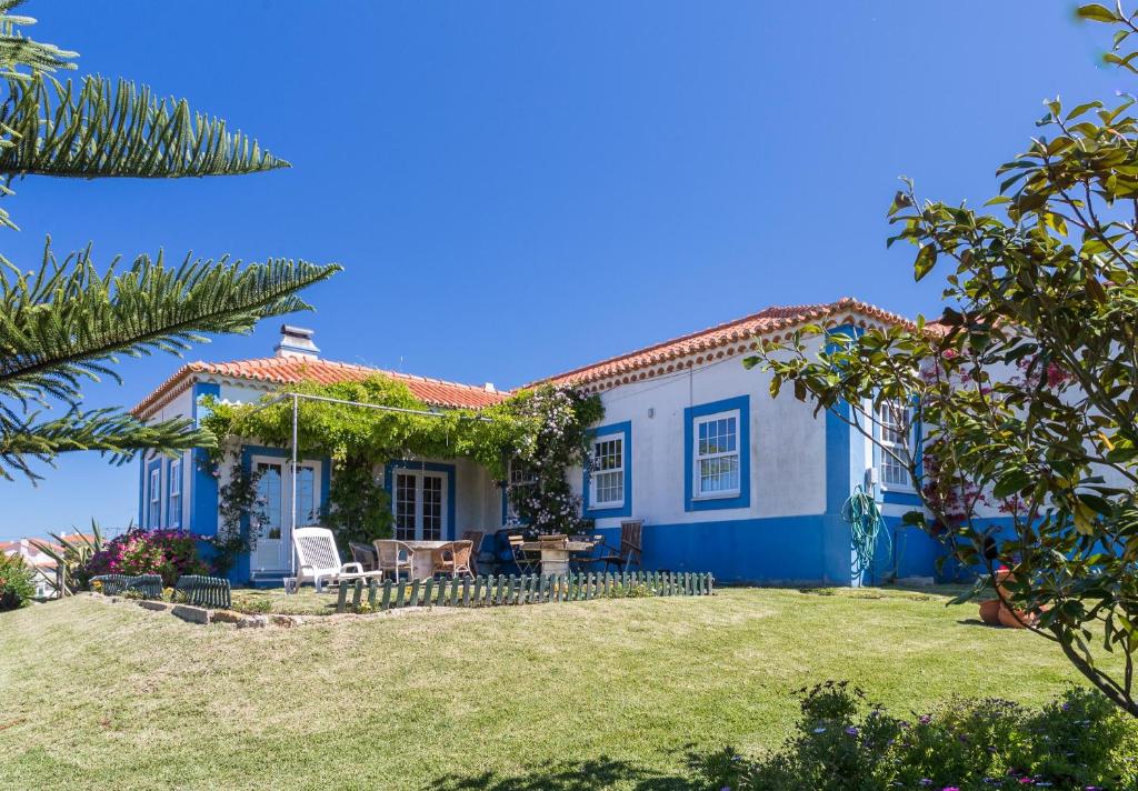una casa azul y blanca con patio en FLH Ericeira Country House, en Ericeira