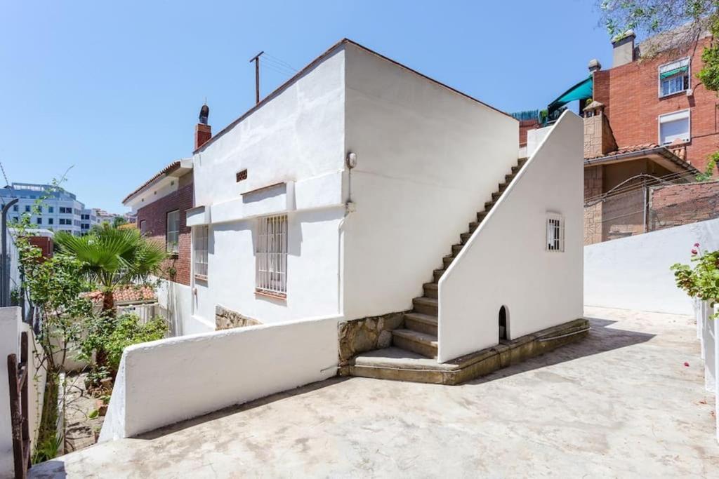 Una casa blanca con escaleras al costado. en Bed&BCN Baro, en Barcelona