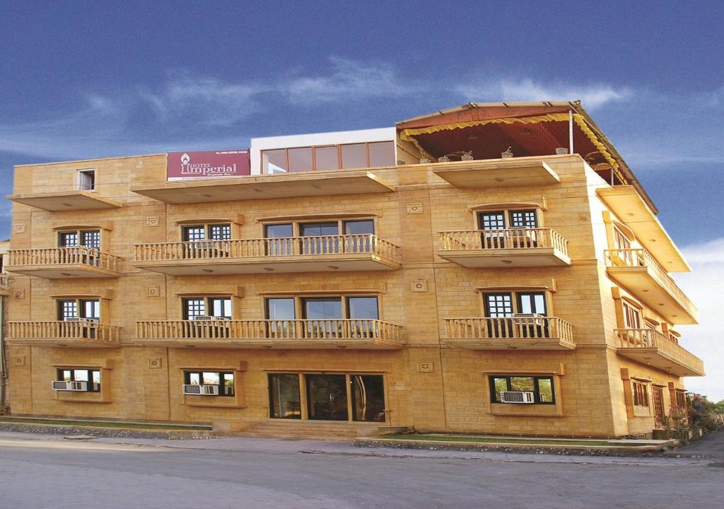 ein großes Backsteingebäude mit seitlichen Balkonen in der Unterkunft Hotel Imperial in Jaisalmer