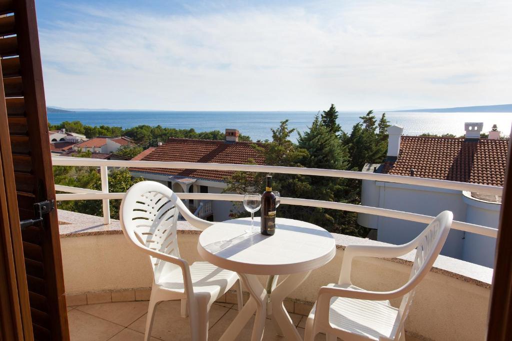 a white table and two chairs on a balcony at Apartman Vjekoslav in Krk
