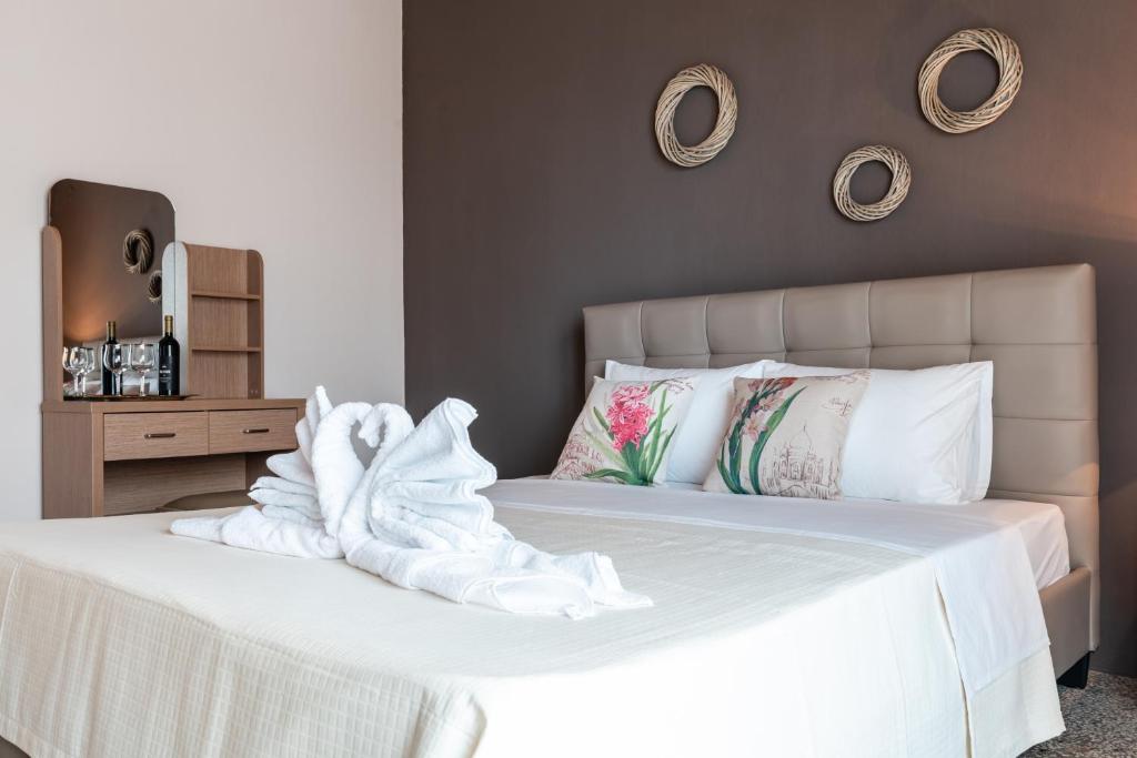 a white bed with a pile of towels on it at Roxanne’s Home in Limenas