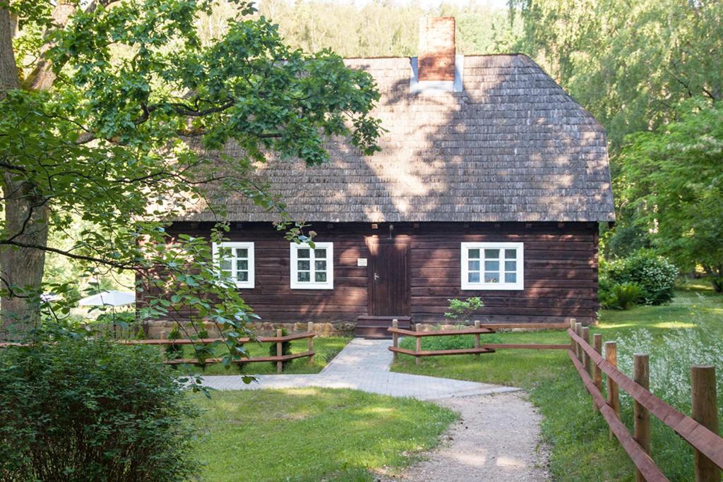 una pequeña casa de madera con una valla alrededor en Viesu māja Sprīdīši en Tērvete