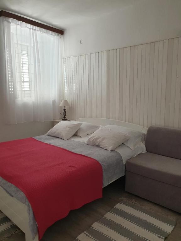 a bedroom with a large bed and a couch at Apartments Neda in Drače
