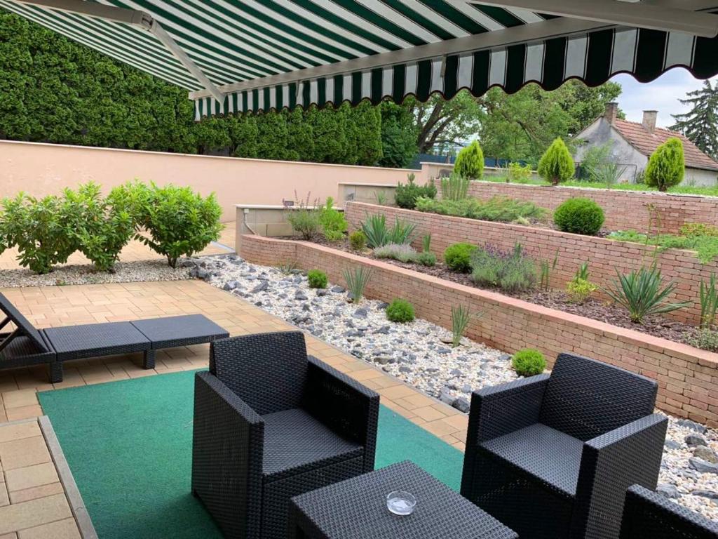 patio z krzesłami i stołem oraz ogród w obiekcie Villa Mona Lisa w Hévízie