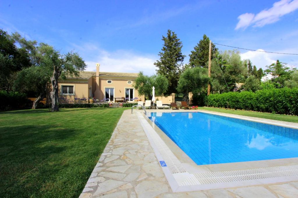 une maison avec une piscine dans une cour dans l'établissement STONE ROSE VILLA, à Ágios Ioánnis