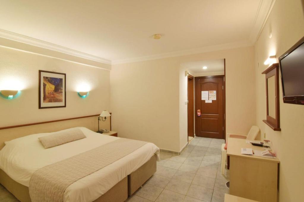 A bed or beds in a room at Olympos Hotel - Adults Only