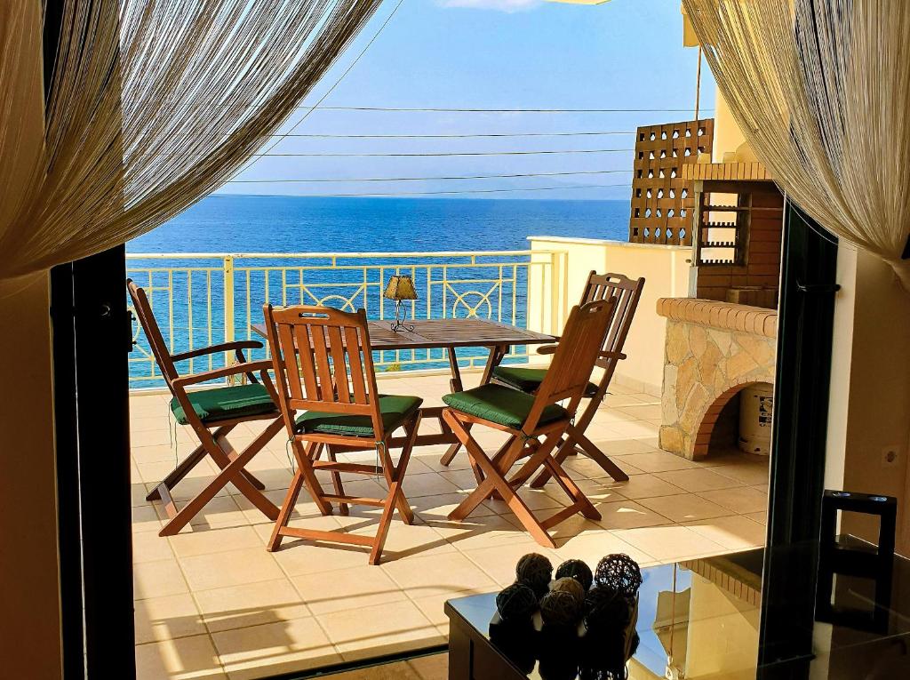 a balcony with a table and chairs and the ocean at Derveni Seaside Apartments "Penthouse" in Derveni