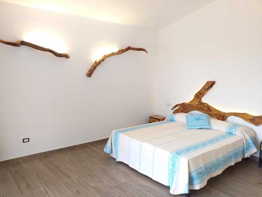 una camera da letto con un letto a parete con un ramo di albero di Turismo Rurale Lu Stazzu Arzachena a Arzachena