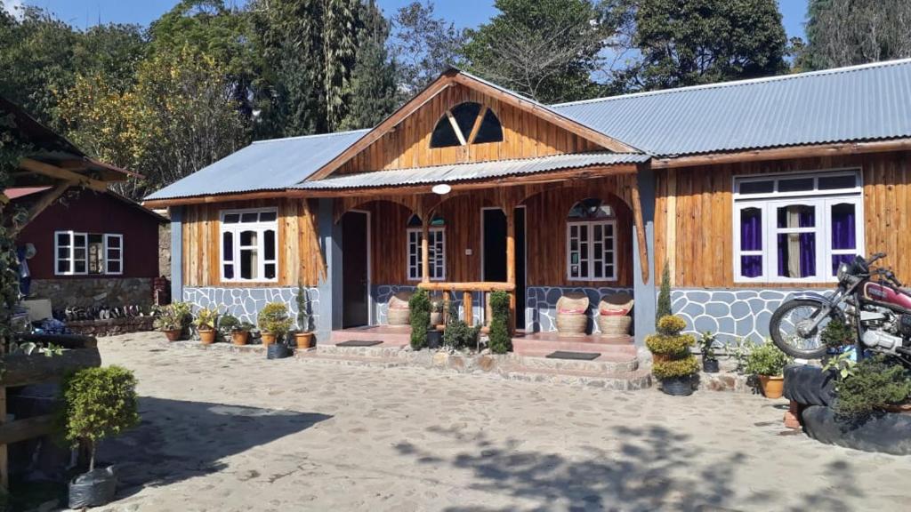 a wooden house with plants in front of it at Vamoose Sunakhari in Mirik