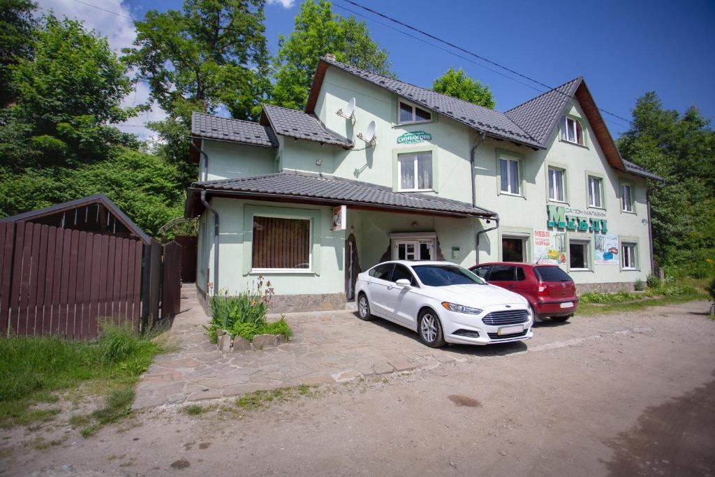 two cars parked in front of a house at Synyogora in Yaremche