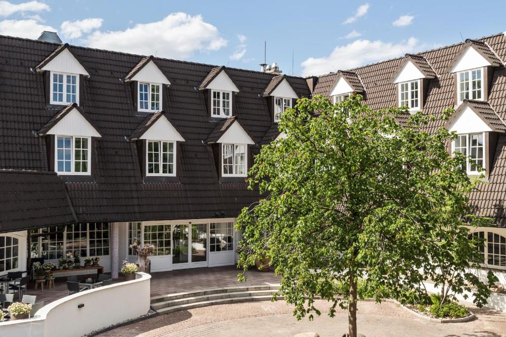 an apartment building with a black roof at Seehotel Villago in Eggersdorf