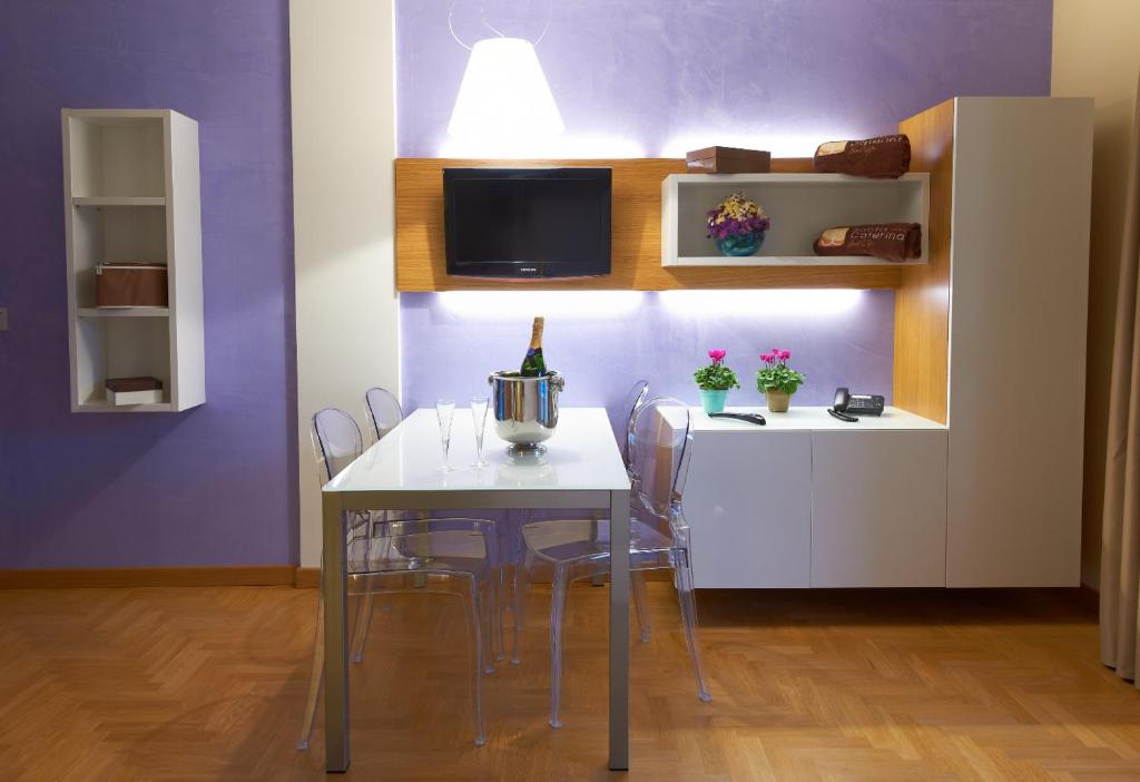 a dining room with a table with chairs and a wine bottle on it at Santa Caterina Resort in Santa Caterina di Nardò