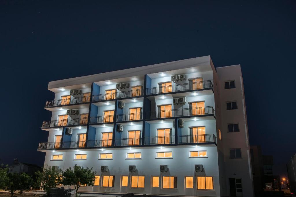un edificio alto con ventanas iluminadas por la noche en Deniz Airport Suites, en Lefkosa Turk