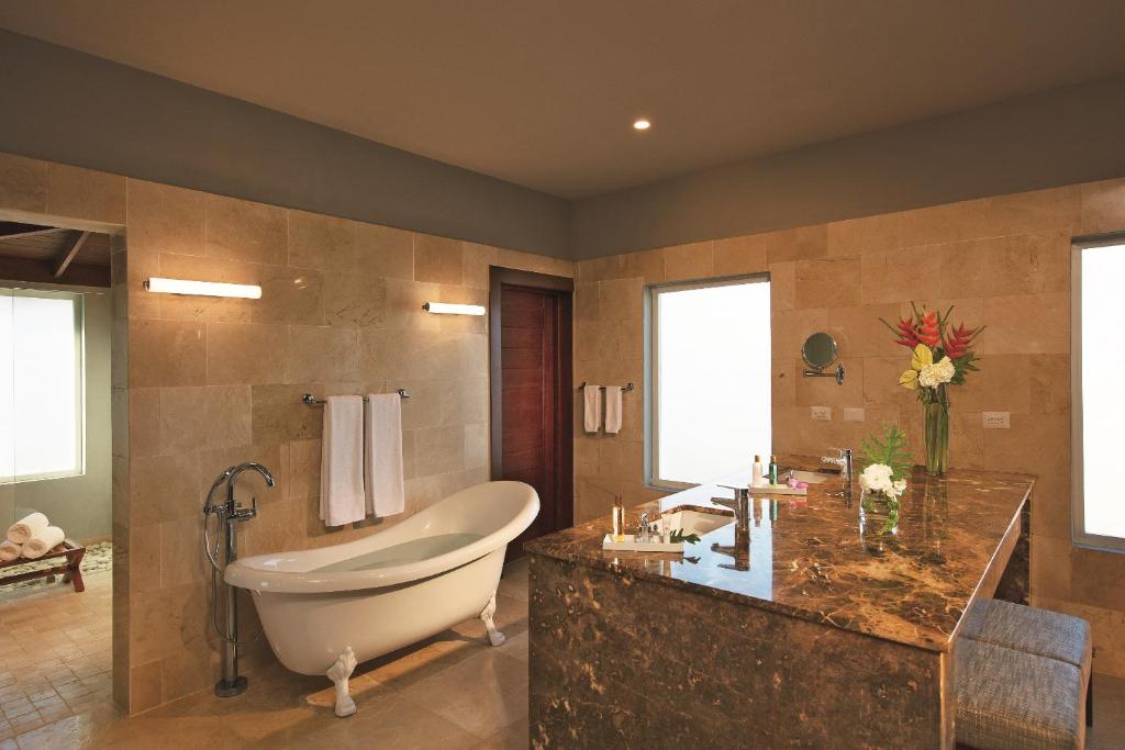 a large bathroom with a tub and a sink at Dreams Dominicus La Romana Resort & Spa in Bayahibe