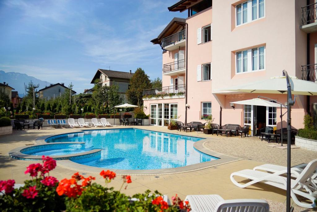 a swimming pool in front of a building at Hotel Bellaria in Levico Terme