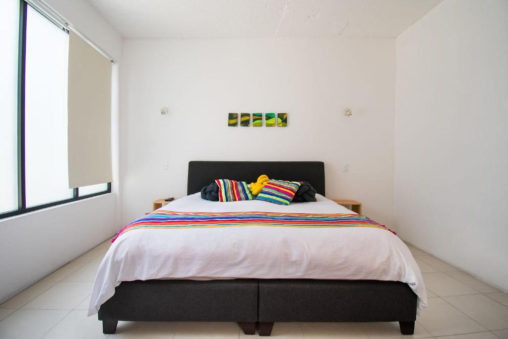 Un dormitorio con una cama con almohadas de colores. en FL 59 Coyoacan at your doorstep!, en Ciudad de México