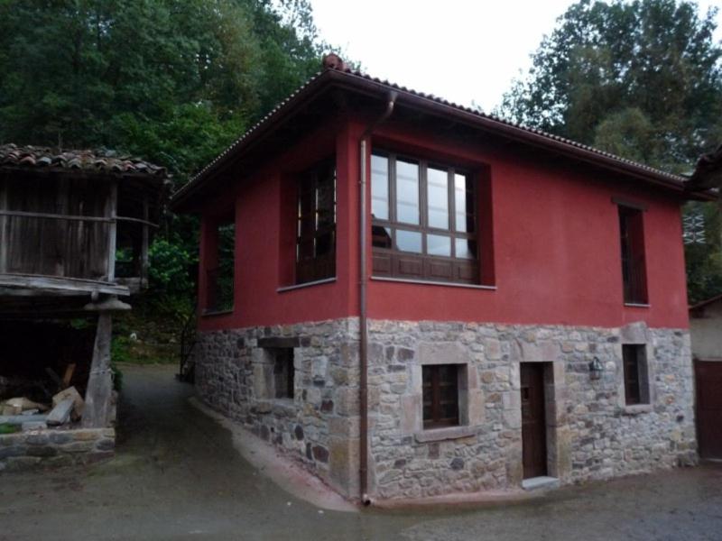 a red building with windows and a building at Casa AL ABLUGO in Pola de Somiedo