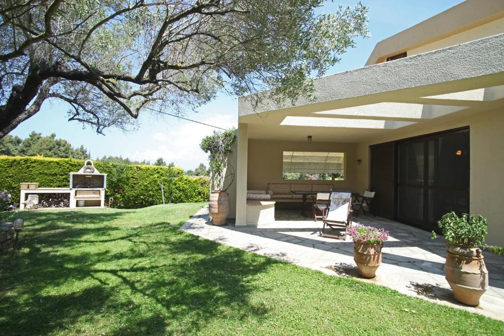 a patio of a house with a grass yard at #Luxlikehome - Villa Sanni Retreat in Sani Beach