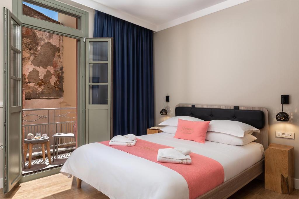 1 dormitorio con 1 cama grande y balcón en Viaggio Elegant Rooms en La Canea