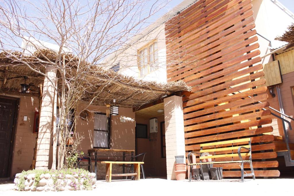 een houten muur aan de zijkant van een huis bij hostal iquisa in San Pedro de Atacama