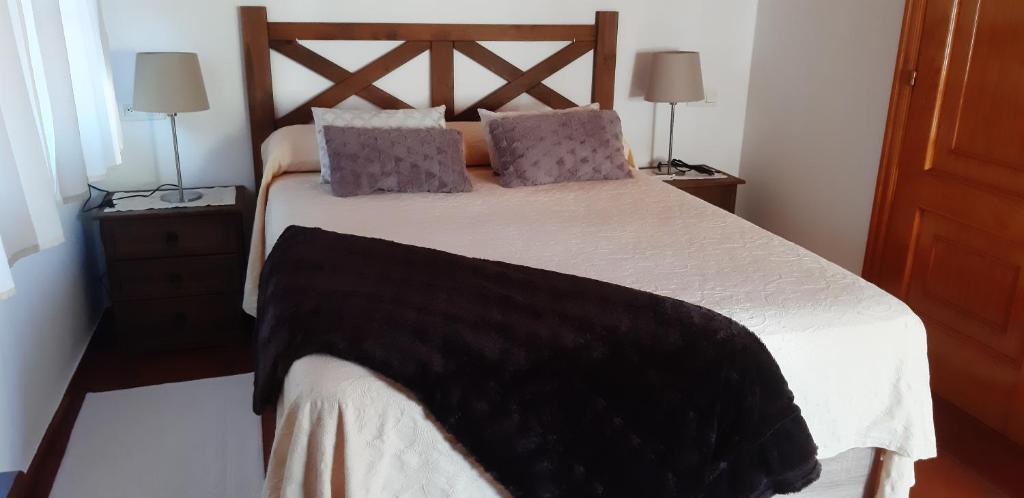 una camera con un grande letto e due lampade di Ático en Pontevedra ciudad a Pontevedra