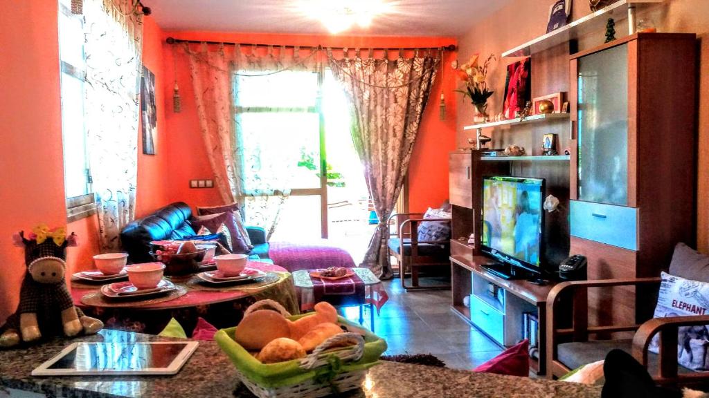 a living room with orange walls and a table at Deluxe garden flat near Terra-M&iacute;tica in Benidorm