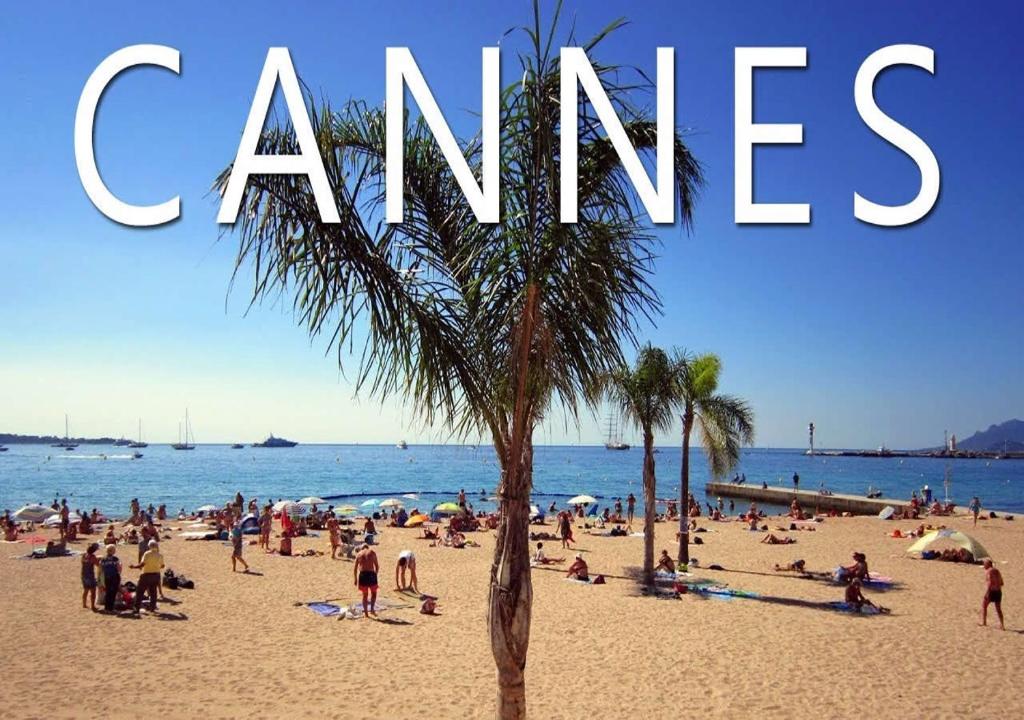 Un groupe de gens sur une plage avec les mots inquiets dans l'établissement Central Park Apartment, à Cannes