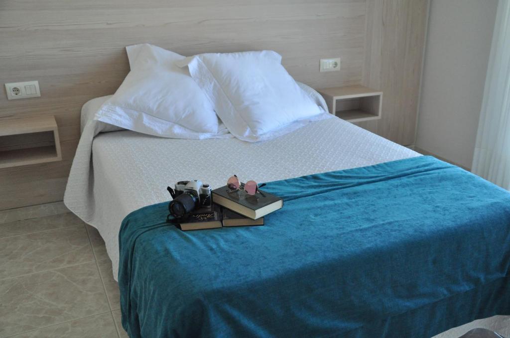 a hotel room with a bed with a blue blanket at Hotel Casa Portuguesa in Meaño
