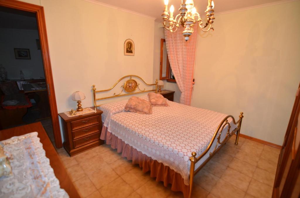 una camera con letto, cassettiera e lampadario a braccio di Casa Maria a Camaiore