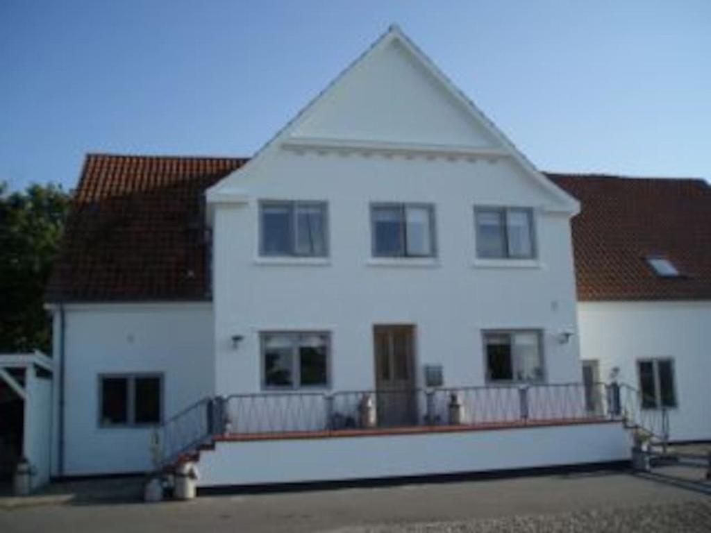 a large white house with a large balcony at BB-Vadehavet Ferielejlighed til 6 personer ved Nationalpark Vadehavet in Ribe