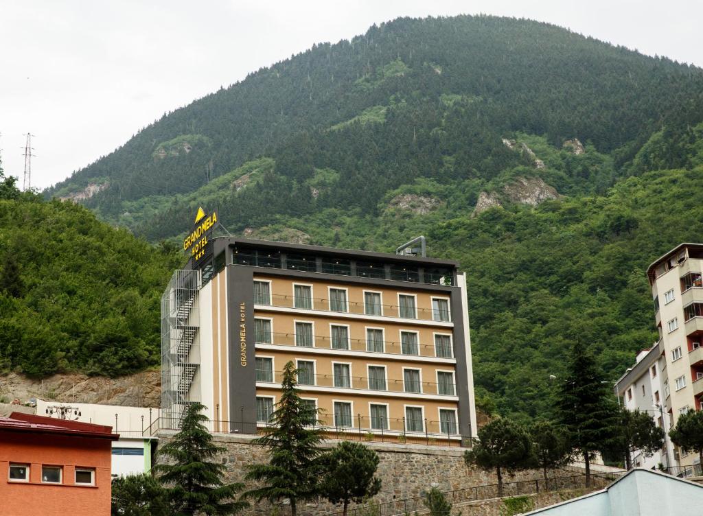 a building with a mountain in the background at Grand Mela Hotel in Macka