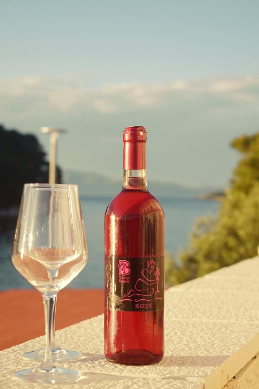 - une bouteille de vin à côté d'un verre de vin dans l'établissement Mljet Sunset Apartments, à Pomena