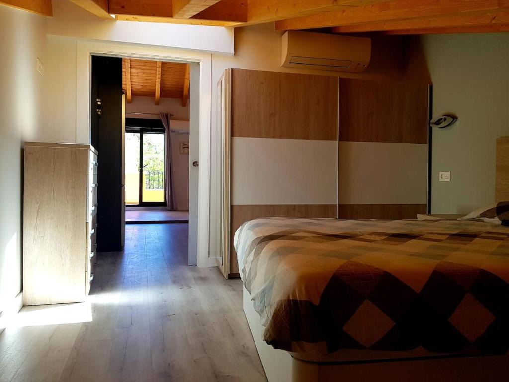 1 dormitorio con 1 cama y puerta que da a un pasillo en Apartamentos Aranda - Ático Duero, en Aranda de Duero