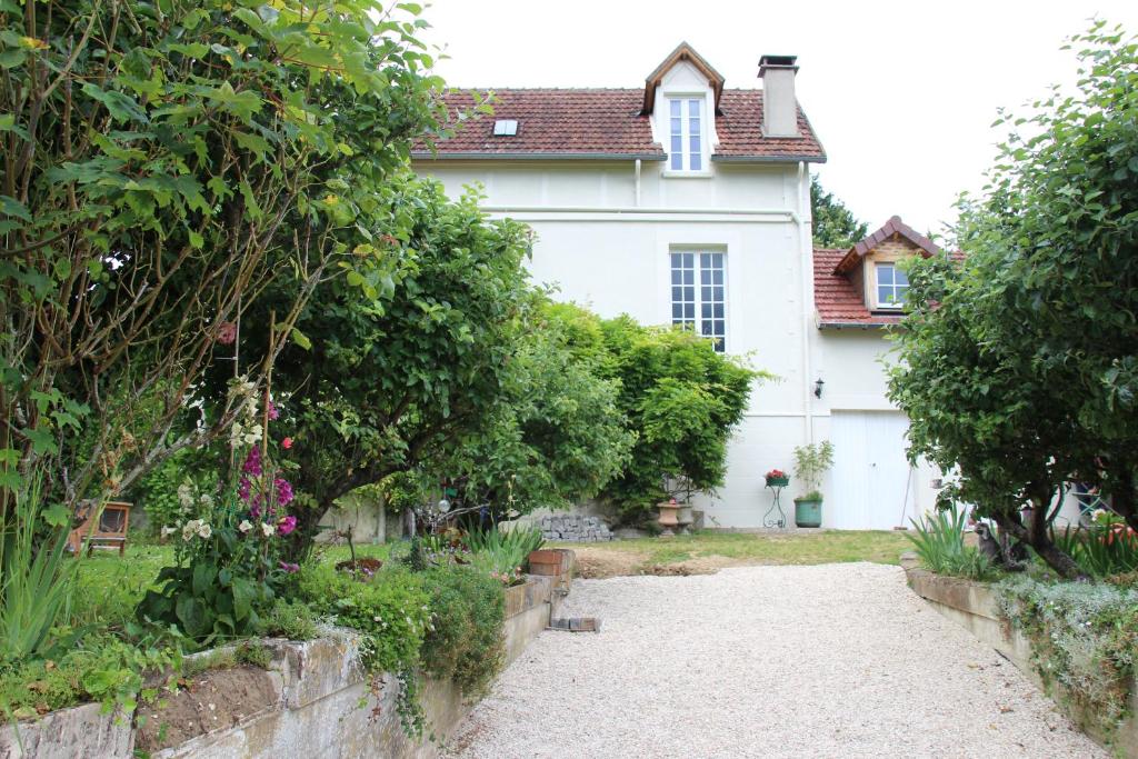 une maison blanche avec un jardin en face dans l'établissement Belle Vue Terrasse, à Giverny