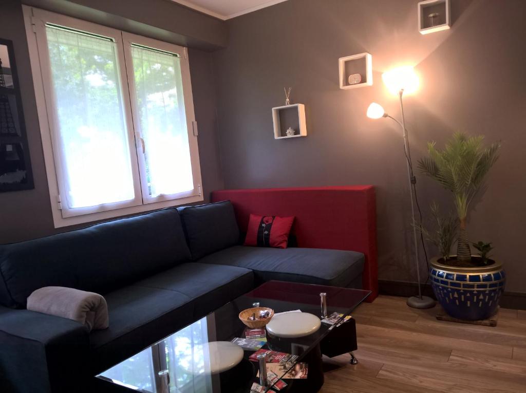 a living room with a blue couch and a window at Charmant F2 Paris Expo Versailles in Vanves