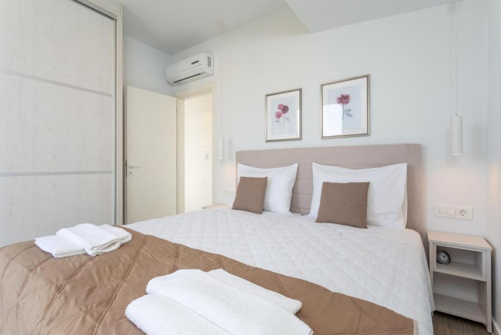 a white bedroom with a large bed with white pillows at CasAlma II in Tsilivi