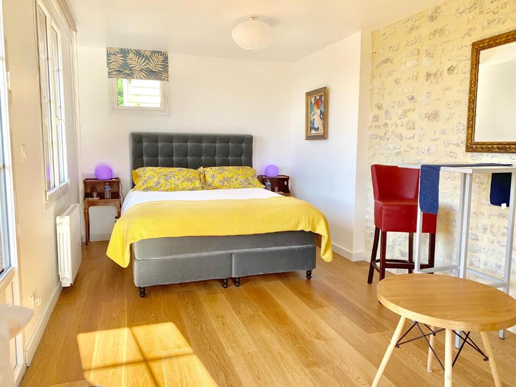 a bedroom with a bed and a table and a chair at Villa kahlo Omaha Beach in Colleville-sur-Mer