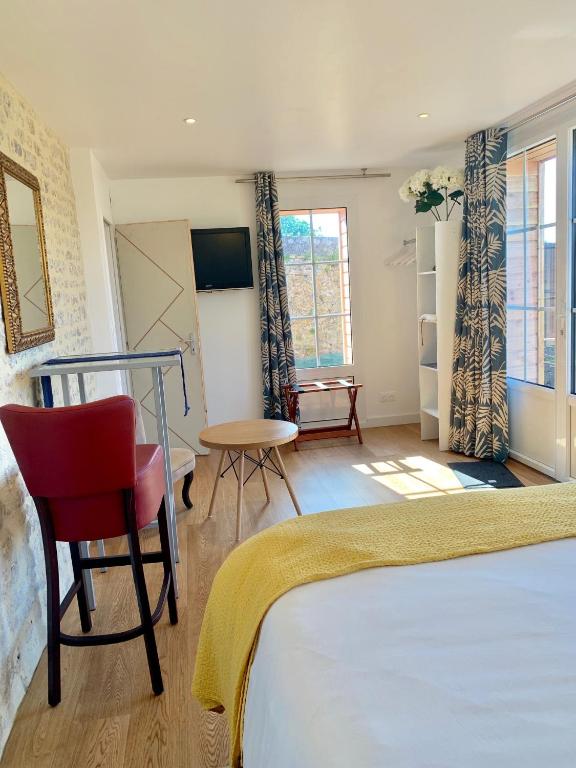 a bedroom with a bed and a red chair at Villa kahlo Omaha Beach in Colleville-sur-Mer