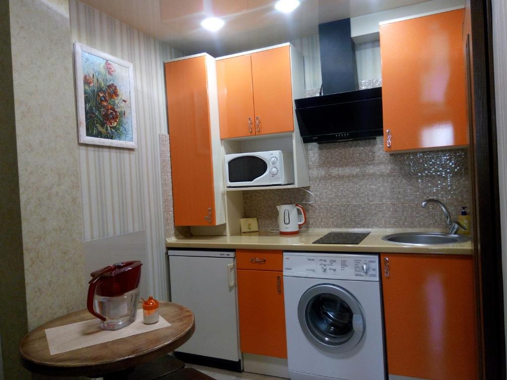 cocina con armarios de color naranja y lavadora en АРТГАЛЕРЕЯ у серці Львова en Leópolis