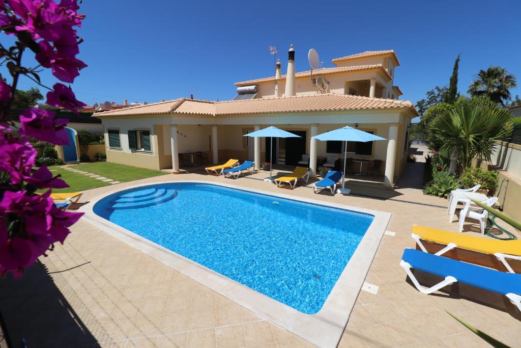 a villa with a swimming pool in front of a house at VILLA EBER - independent 1 & 2 bedroom apartments, pool, air con, fast Wi-Fi, near old town of Albufeira and beaches in Albufeira