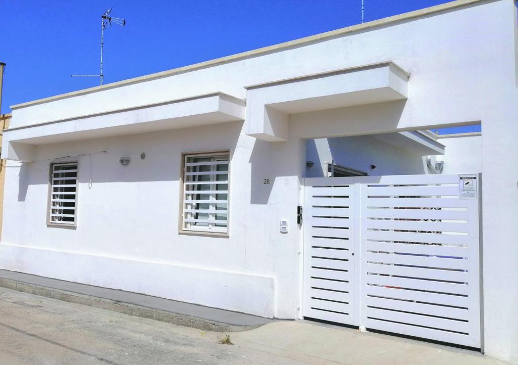 a white house with a white garage door at DoppioBi in Torre Lapillo