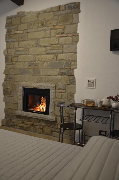 una chimenea de piedra en una habitación con cama en B&B La Casa Sulla Roccia en Pietrapertosa