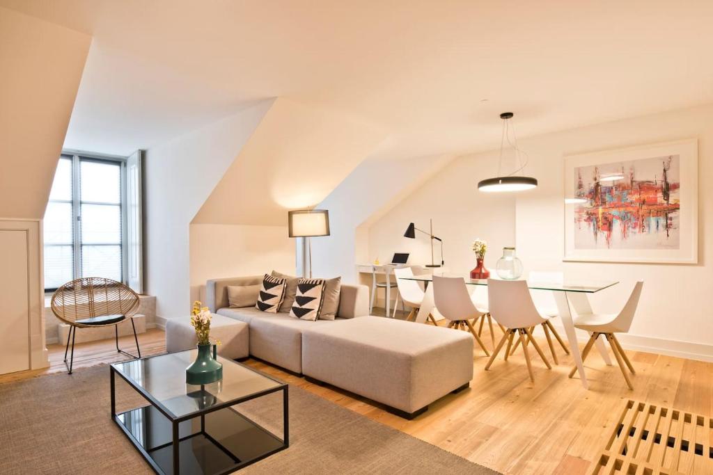 uma sala de estar com um sofá e uma mesa em Penthouse with River View - Baixa Alfama em Lisboa