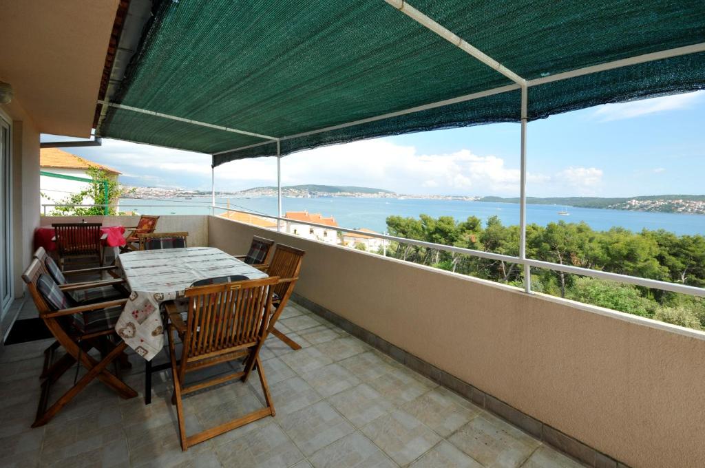 balcone con tavolo, sedie e vista sull'acqua di Apartment Sandra a Trogir