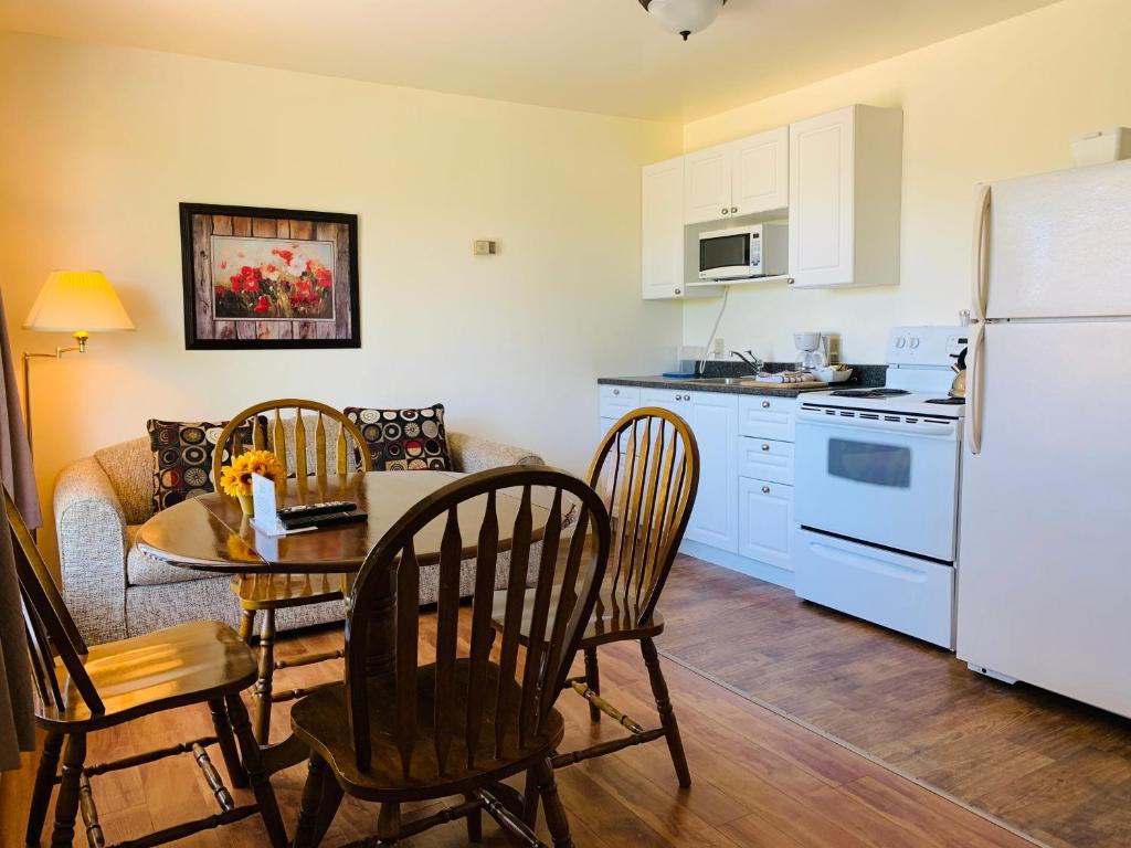 a kitchen with a table and chairs and a refrigerator at Fair Isle Motel in Charlottetown