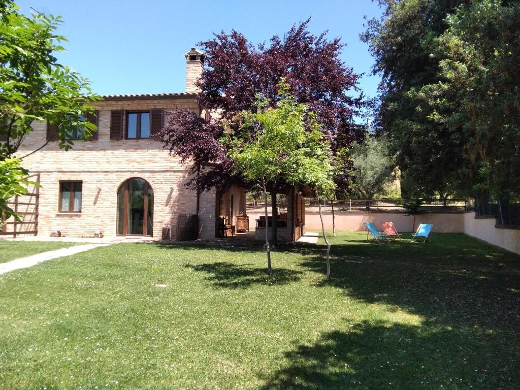 une maison avec une cour avec deux chaises et un arbre dans l'établissement B&B IL LEPRICE, à SantʼElpidio a Mare