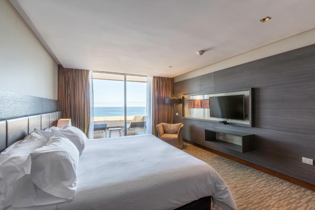 pokój hotelowy z łóżkiem i telewizorem z płaskim ekranem w obiekcie Enjoy Antofagasta w mieście Antofagasta