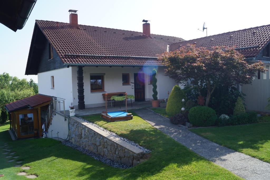 una pequeña casa blanca con una pared de piedra en Ferienwohnung Hofbauer, en Hofkirchen