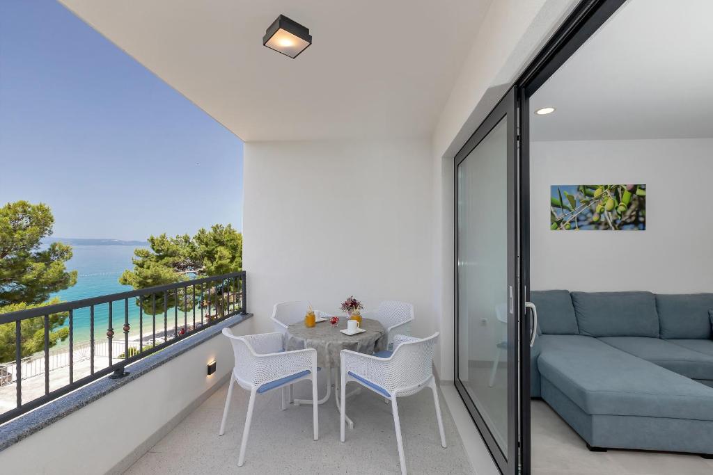 a balcony with a table and chairs and a couch at Central Beach Apartments in Tučepi