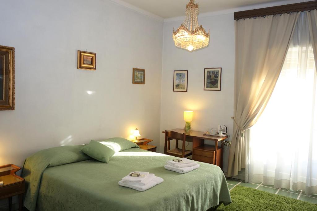 Un dormitorio con una cama verde y una lámpara de araña. en B&B Rome Downtown Deluxe, en Roma